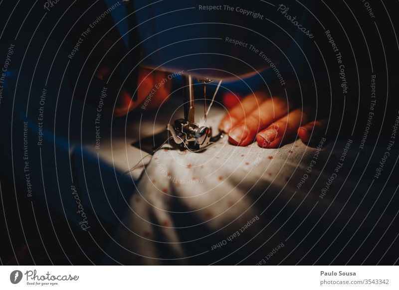 Nahaufnahme von Händen, die Stoff durch die Nähmaschine führen Nähgarn Nähen Nadel mehrfarbig Handarbeit Schneidern Farbfoto Innenaufnahme Mundschutz diy