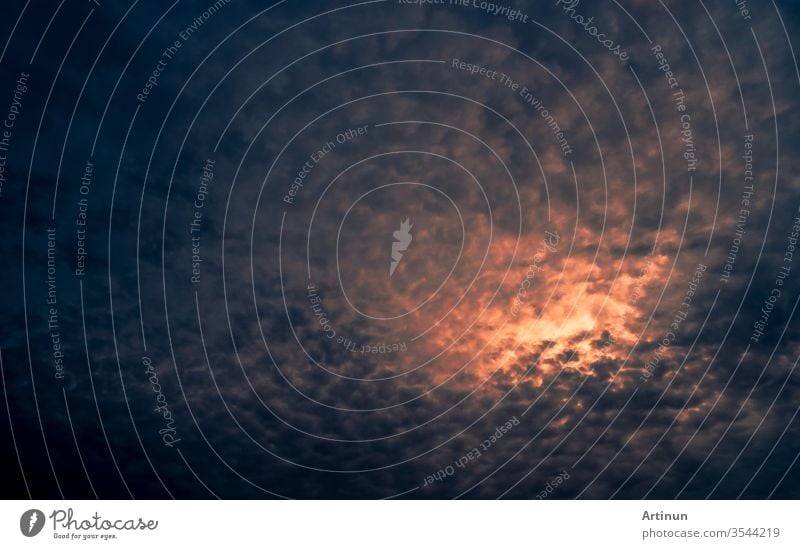 Rotes Sonnenlicht am dunkel bewölkten Himmel bei Sonnenuntergang. Dramatischer Himmel mit schönem Muster aus flauschigen Wolken. Geistige Kraft oder psychischer Machthintergrund. Kraft der Natur. Exotische Wolkenlandschaft. Konzept des Klimawandels.