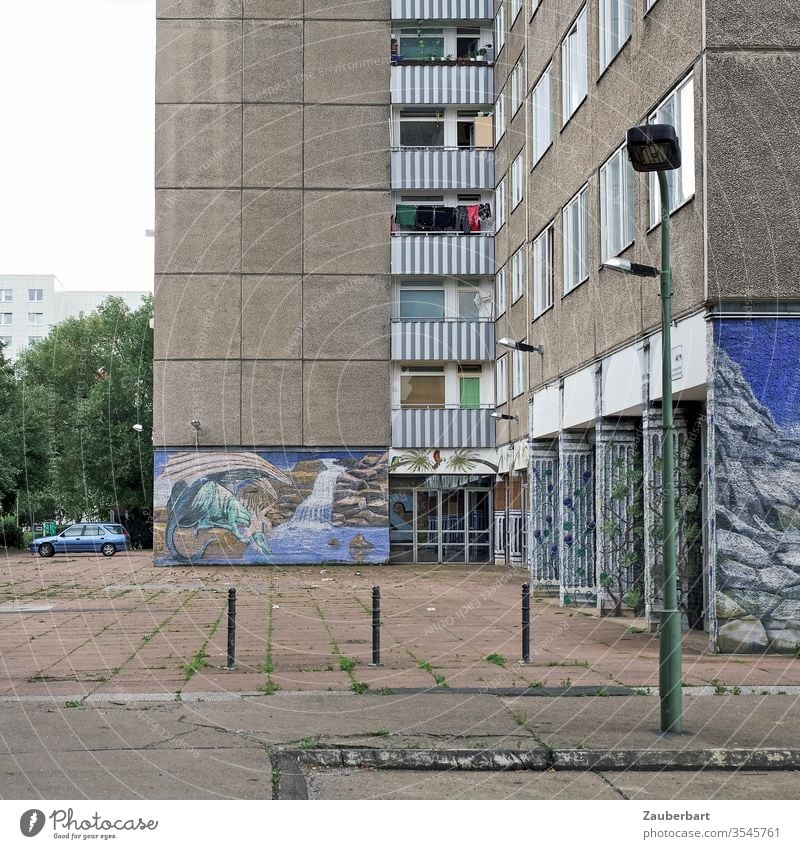 Plattenbau mit Hof, Gehweg, Malereien und Laterne Fassade Wohnhaus Berlin Lichtenberg blau Wandmalerei Poller Gebäude Stadt Menschenleer Haus Fenster Balkon