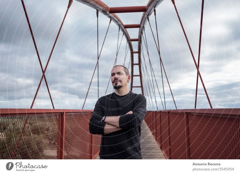 Kahlköpfiger, kühler Mann im Porträt einer Fußgängerbrücke Brücke kahl Freizeitkleidung Tag tagsüber Ethnizität Mode modisch gutaussehend Glück Spanien