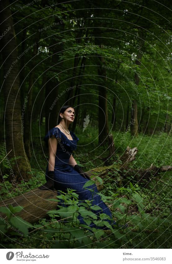 Estila frau feminin wald sitzen schauen beobachten dunkel grün wild kleid handschuhe langhaarig zopf kette dunkelhaarig