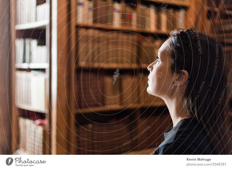 Blick nach vorn in die historische Bibliothek. Studentin ist in Bibliothek, die voller Bücher ist. allein Buch frei Vorderseite traumhaft menschlich