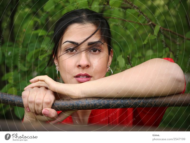 Estila frau feminin schauen beobachten grün kleid langhaarig zopf dunkelhaarig wald auflehnen metall metallstange windig wehen busch