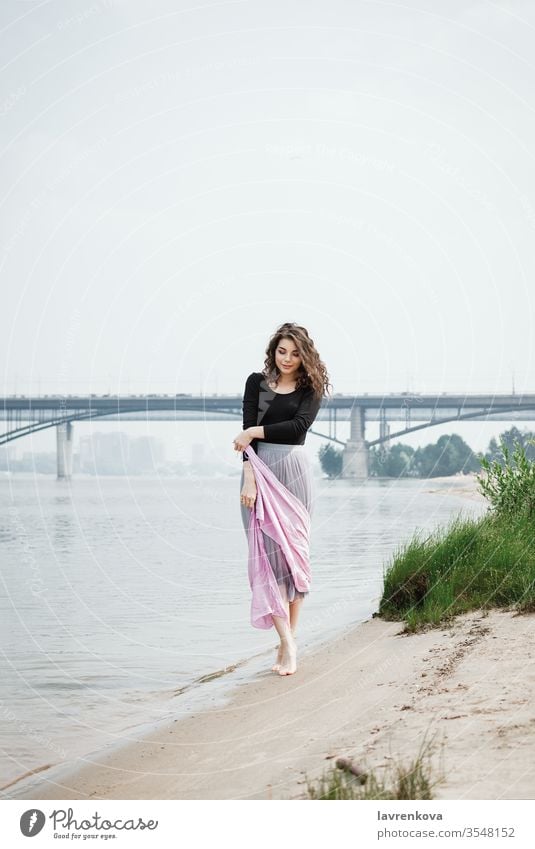 Junge Frau, die mit einem rosa Schal in der Hand am Strand spazieren geht, selektiver Fokus Erwachsener Rücken Schönheit Braut Kaukasier Kleid gesichtslos