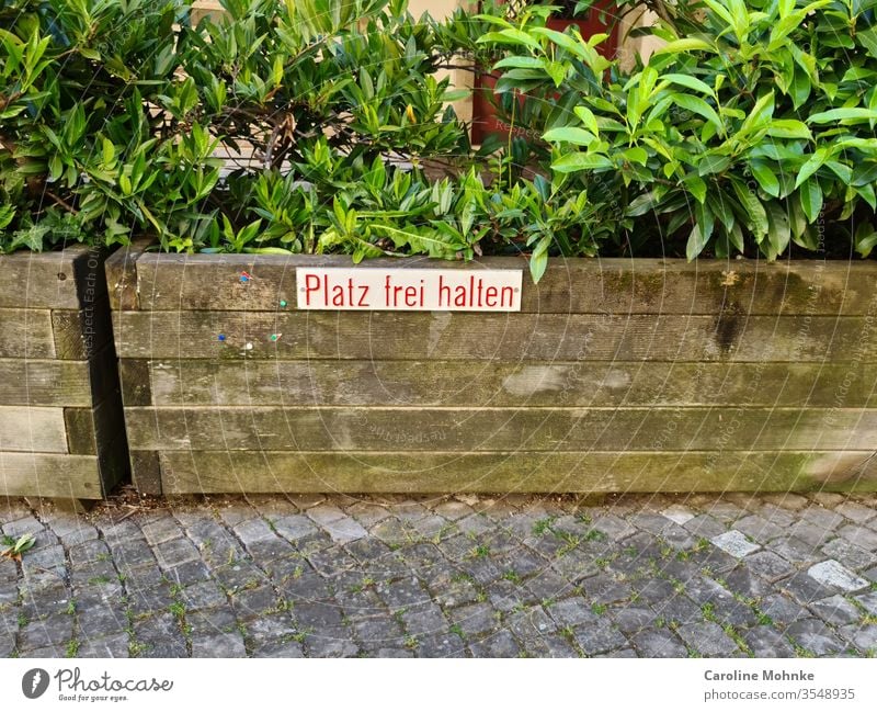 Schild Platz frei halten auf Pflanzenkiste Schilder & Markierungen Außenaufnahme Hinweisschild Farbfoto Menschenleer Schriftzeichen Warnschild Zeichen Tag