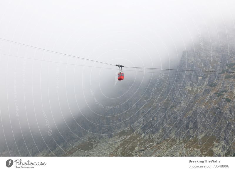 Rote Bergbahn in Wolken und Nebel, Seitenansicht mit niedrigem Winkel Seilbahn PKW rot heben Berge u. Gebirge Landschaft Kabel Weg Antenne Luftbrücke Eisenbahn