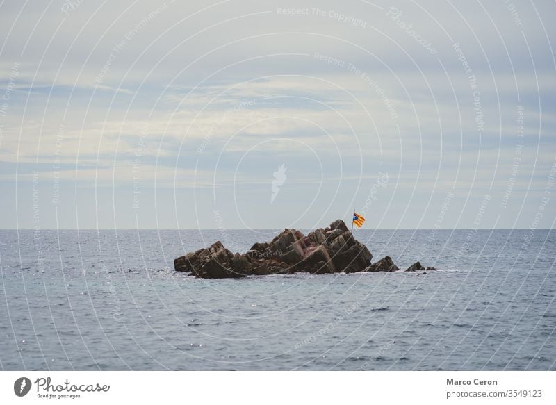 Die Flagge weht auf einer Wüsteninsel in der Mitte des Meeres Fliege Fahne nationalistisch Inselchen Fliegen MEER Himmel Wasser Emblem Felsen symbolisch