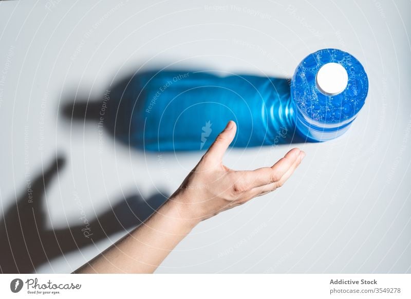 Nicht erkennbare Person, die Hand für Flasche Glitzerwasser zieht Wasser Schatten funkeln durchsichtig Kunststoff natürlich sich[Akk] melden rein Klebeband satt