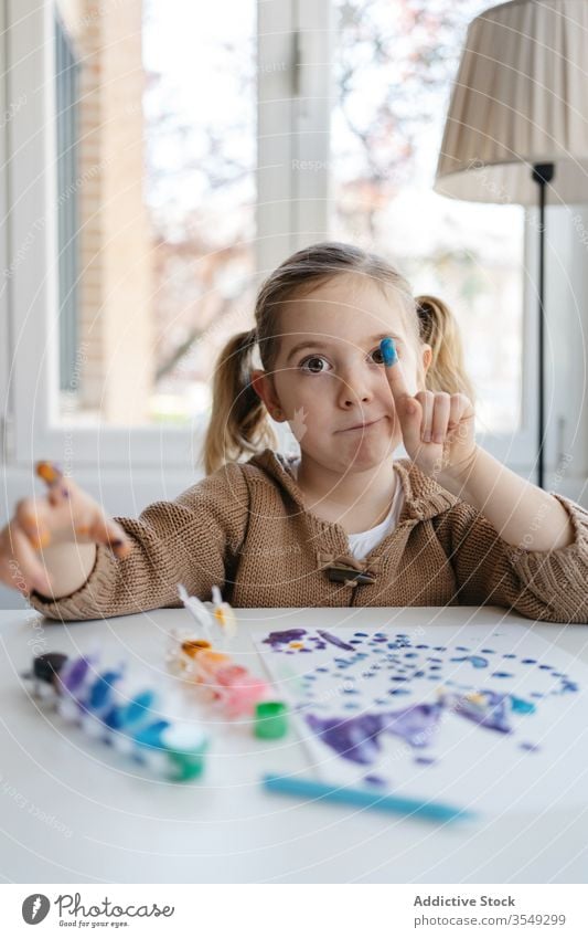 Kleines Mädchen zeigt Finger mit Gouache beim Zeichnen im Wohnzimmer Farbe Papier zeigen zeichnen Punkt spielerisch niedlich Vorschule Zeichnung abstrakt Bild