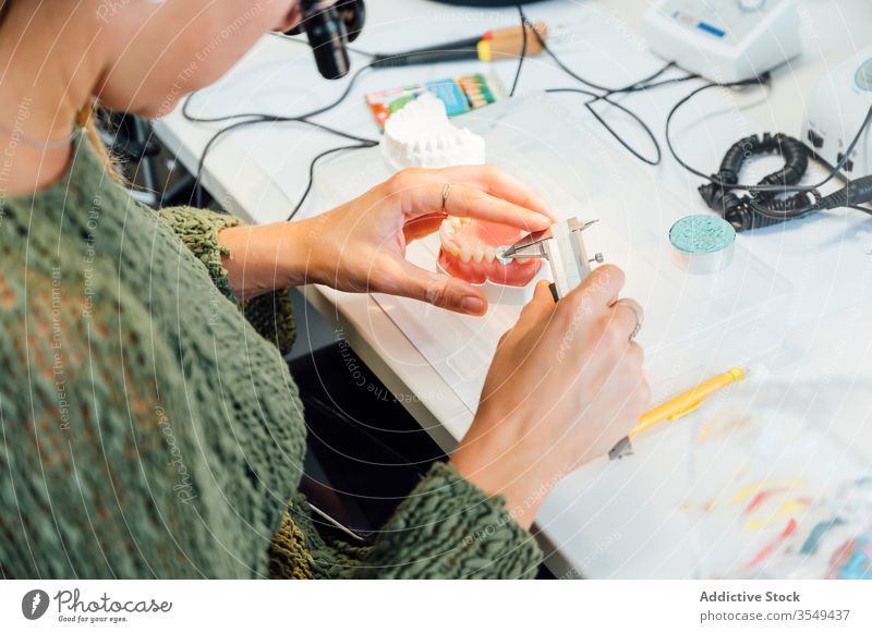 Zahnmedizinstudent misst Zahn während des Unterrichts messen Prothesen Werkzeug Schieblehre Kiefer Medizin Gerät lernen Bildung Tisch Instrument