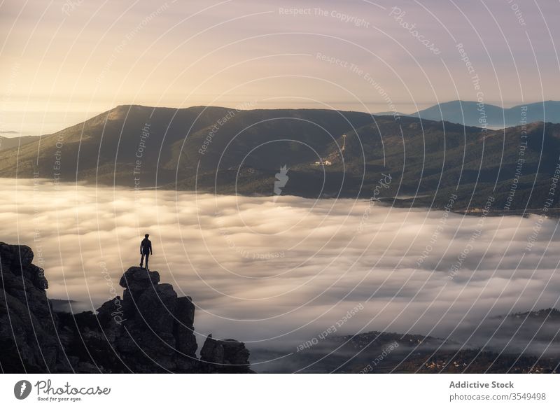 Reisender steht auf felsigem Berg Berge u. Gebirge Felsen Cloud Nebel reisen Landschaft Natur Wanderung Klippe Gipfel Freiheit Inspiration Tal Tourist prunkvoll