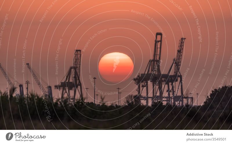 Industriekräne gegen den Sonnenuntergangshimmel rot Kranich Landschaft Silhouette Windstille ruhig dunkel Himmel Abend Skyline Sommer Abenddämmerung Dämmerung