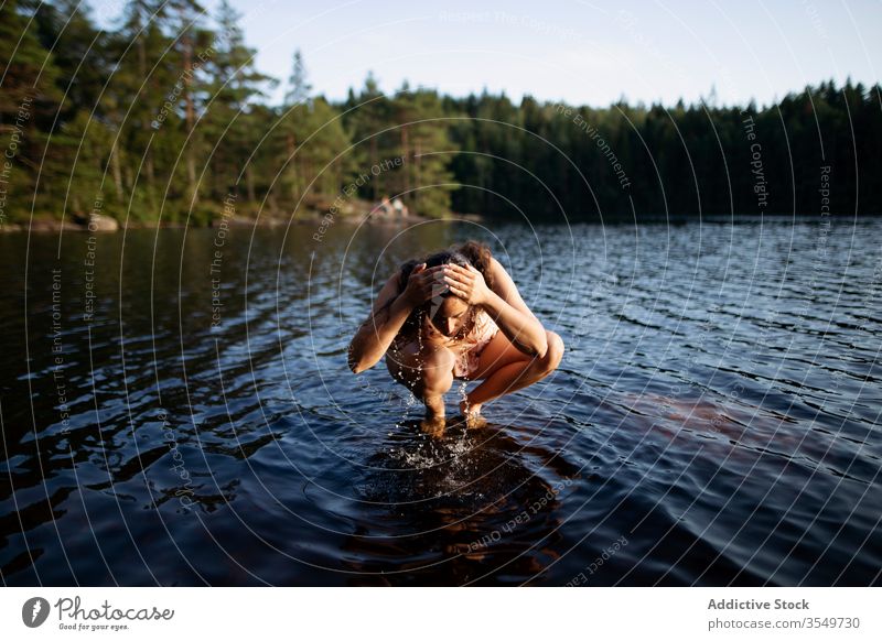 Frau wäscht während der Sommerferien im Fluss ihr Gesicht Waschen Wald Sonnenuntergang majestätisch Landschaft Wasser Barfuß ruhig Windstille Rippeln Harmonie