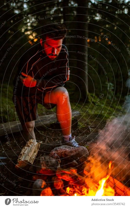 Mann mit Brennholz beim Lagerfeuermachen im Wald Wohnmobil Freudenfeuer Nacht Totholz Aufwärmen männlich Windstille Reisender ruhig Wälder genießen Wochenende