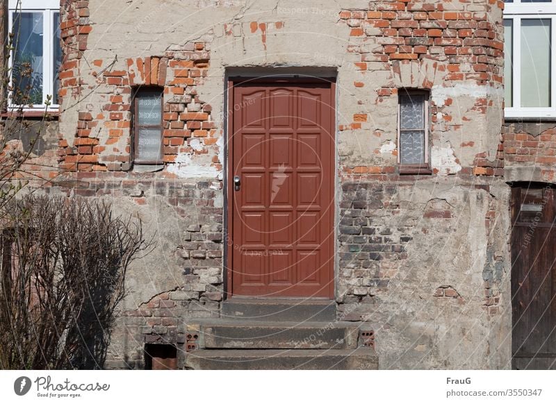 alt | das Haus -die Tür ist neuer Fassade Backsteinfassade Putz Haustür Zahn der Zeit Fenster Gardinen Treppenstufen wohnen Busch Wand verfallen Mauer Verfall