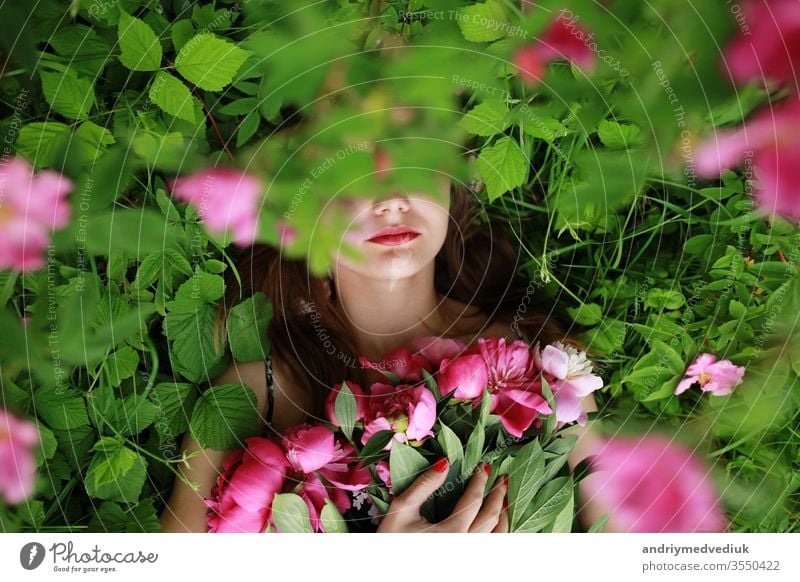 Strauß Pfingstrose. schöne junge Frau liegt unter Pfingstrosen. Feiertage und Veranstaltungen. Valentinstag. Frühlingsblüte. Blumen Porträt Glamour rosa