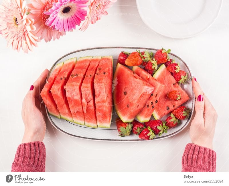 Wassermelonenscheiben auf Tablett auf weißem Holztisch Sommer erdbeeren Scheiben Keramik Hände rosa hölzern Frau Tisch frisch Snack Beeren Blumen lecker schön