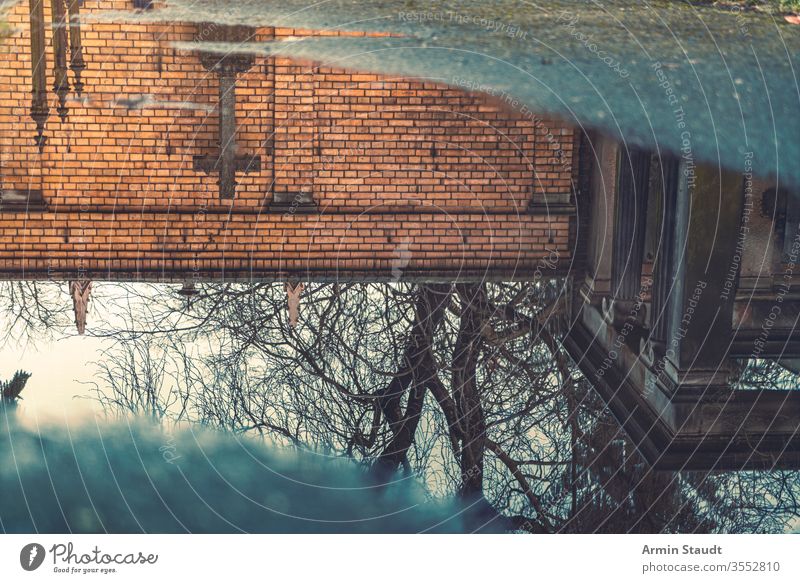 Spiegelung eines Kreuzes in einer Pfütze Wasser durchkreuzen Verlassen abstrakt antik Asphalt Hintergrund blau Unschärfe verschwommen Ast Baustein übersichtlich