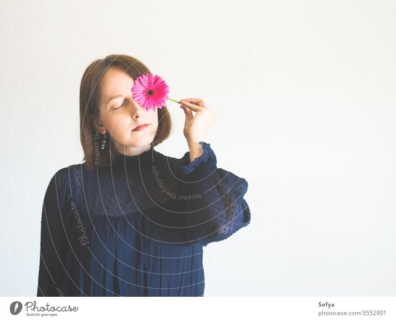 Wunderschönes weibliches Porträt mit rosa Gerbera-Blüte Frau Blume Schönheit Muttertag Mode eine einzigartig Haut Auge Pflege Gesicht jung Hand Beteiligung