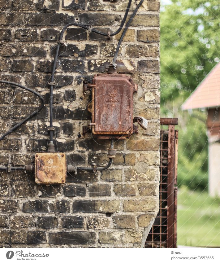 Alter Strom auf alter Mauer alte Mauer Mauerwerk Stromverteiler Stromverteilerkasten rostiges Gitter verfallenes Gebäude Wand Fassade Haus Vergänglichkeit