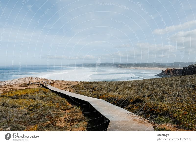 Holzsteg zu einem Aussichtspunkt an den Klippen mit Blick über das Meer und einen Strand an der Algarve, Portugal Bordeira Praia da Bordeira Aussichtsplattform