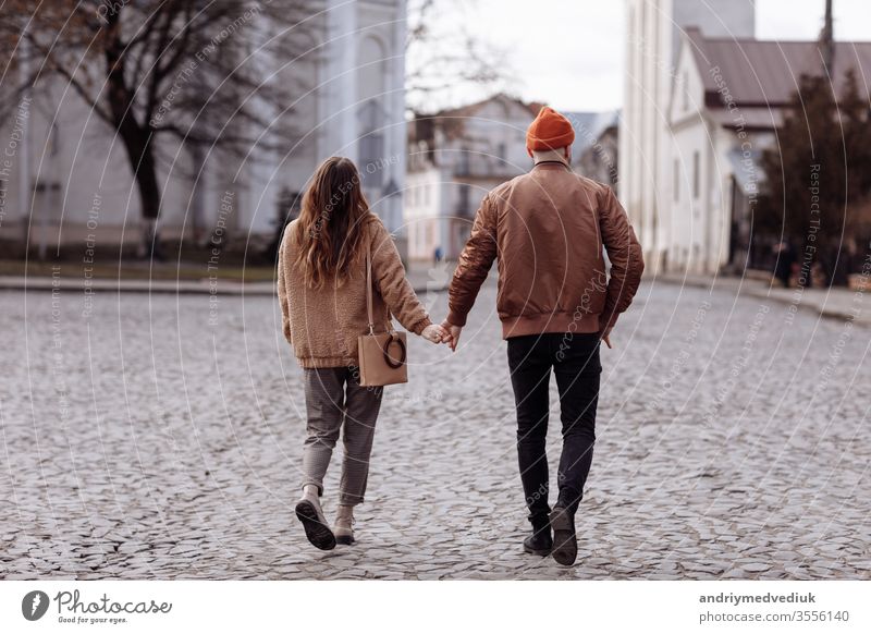 Liebesgeschichte des schönen jungen Mannes und der schönen jungen Frau, die unter freiem Himmel in der Stadt spazieren gehen. Umarmung bei einem Stadtspaziergang. Kopierraum.