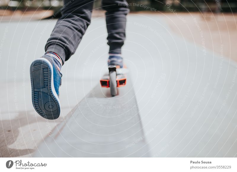 Kind spielt mit Roller Spaß Tretroller Park Menschen jung Kindheit Glück Fröhlichkeit Lifestyle Freude Porträt spielen niedlich im Freien heiter Sommer Schuhe