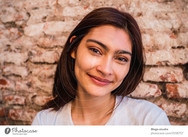 Junge Lateinamerikanerin gegen Ziegelmauer. jung Frau Frauen Straße Baustein urban Backsteinwand schön Hintergrund Erwachsener lieblich Wand Stehen Bild