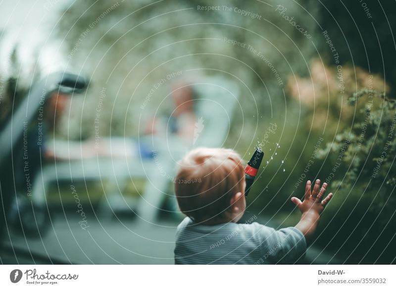 Kind spielt im Garten mit dem Wasserschlauch Junge Gartenarbeit spielend Spielen spass Lebensfreude Fröhlichkeit euphorisch Euphorie nass melancholie Nostalgie