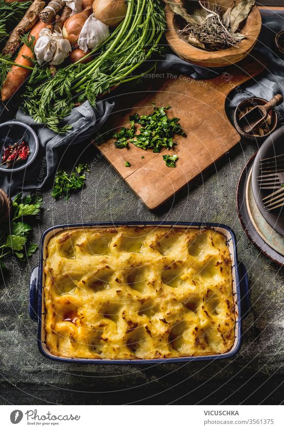 Kartoffelauflauf . Hausgemachtes Kochen. Gehacktes Grünzeug auf Holzschneidebrett. Verschiedene Gemüse und Kräuter. Ansicht von oben. Schmackhafte Hausmannskost