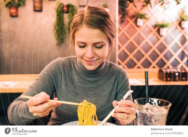 Junge Frau isst Ramen im Cafe essen Café Tradition Japanisch jung Löffel Essstäbchen Schalen & Schüsseln Speise Tisch geschmackvoll Küche Lifestyle Restaurant