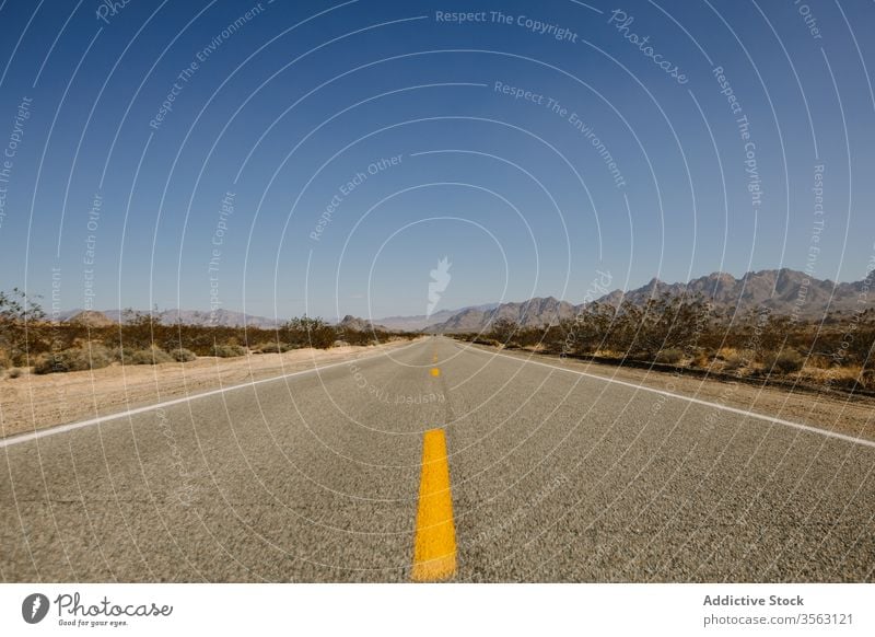 Leere Autobahn auf felsiger Landschaft Straße Autoreise Route wüst Asphalt Sand trocknen erwärmen Berge u. Gebirge malerisch Natur Ausflug Tal Windstille