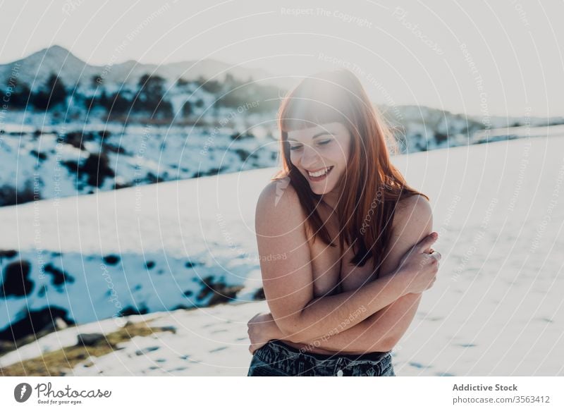 Fröhliche Oben-ohne-Frau in verschneitem Feld oben ohne heiter Schnee Freiheit nackt kalt jung Lachen Landschaft Natur Lächeln Glück Freude Dame positiv Spaß