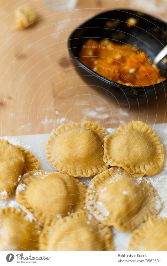 Rohe Ravioli auf dem Tisch in der Küche Schneidebrett rund kreisen besetzen Kürbis Püree Kochen Mehl roh Utensil vorbereiten Lebensmittel Italienisch