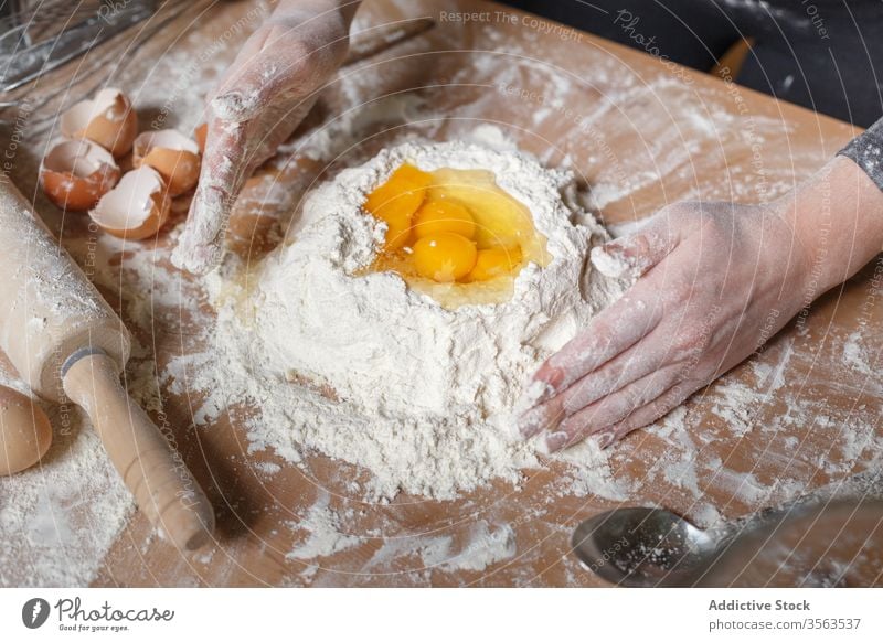 Pflanzenkoch bereitet Teig auf dem Tisch zu Koch Mehl hinzufügen Ei mischen Teigwaren Schulpause vorbereiten Lebensmittel Gebäck Gastronomie Küche Bestandteil