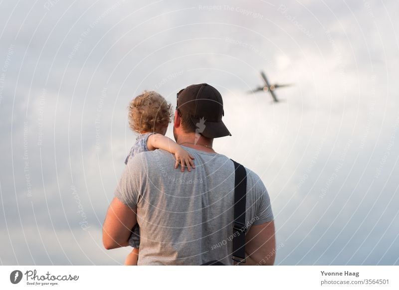 Vater und Kind beobachten ein Flugzeug am Hinmel Strand Himmel Küste Wolken Farbfoto Natur Wind Außenaufnahme Landschaft Wasser schlechtes Wetter Klima Umwelt