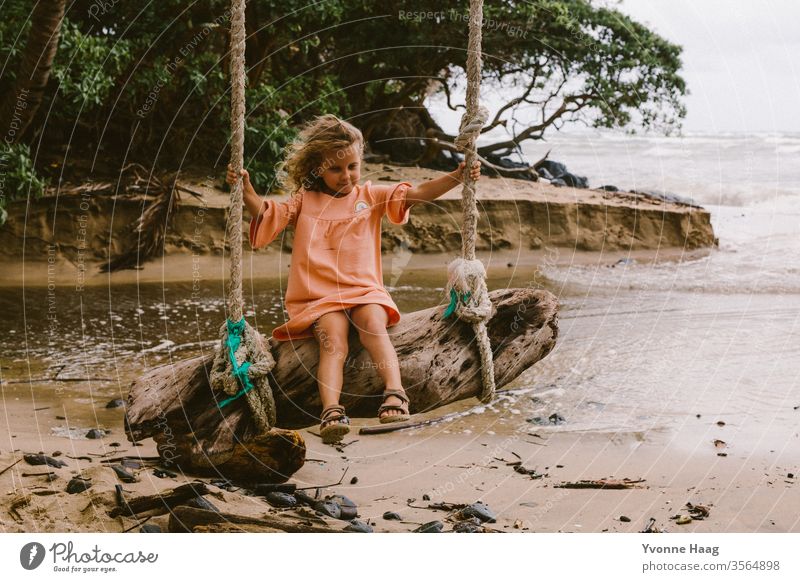 Auf einem großen Baumstamm schaukeln Hawaii Hawaiiblume Schaukelnd Freude Spielen Außenaufnahme Farbfoto Spielplatz Kindheit Tag Kinderspiel Textfreiraum rechts