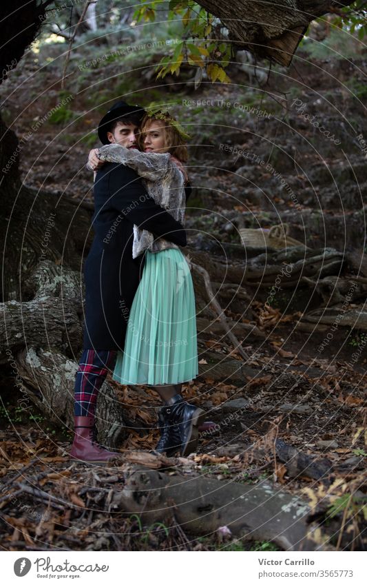 Ein junges Boho-Paar umarmt sich in einem Waldhintergrund Freude Park Spaß Hirsche Freizeit hübsch cool stylisch Herbstlaub Kleid Romantik Land Partnerschaft