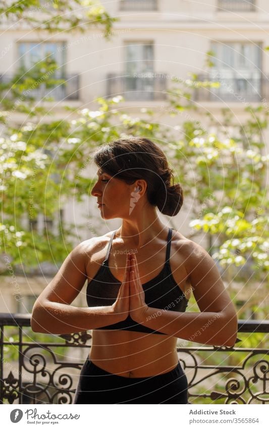 Ruhiges weibliches Stehen in Adlerstellung während der Yogapraxis im Sommer Frau heimwärts üben meditieren Adler-Pose Asana Balkon Windstille Frieden