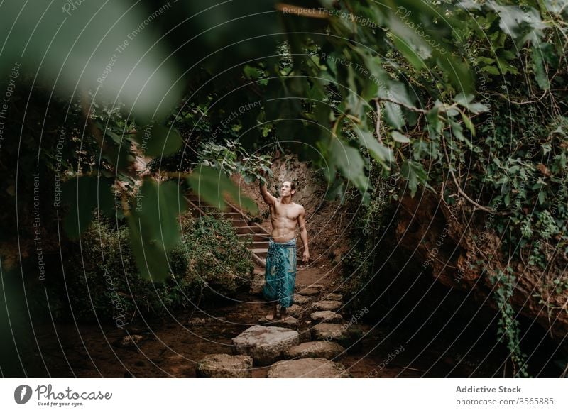 Mann in traditioneller Hose beim Waldspaziergang Sprit Natur Tradition ethnisch Baum Garten ohne Hemd männlich muskulös nackter Torso Barfuß Harmonie ruhig