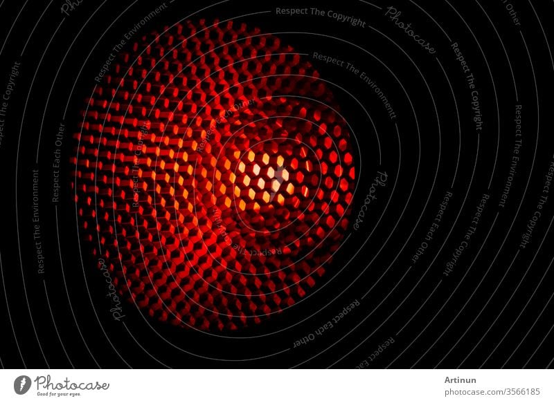 Nahaufnahme Wabengittertextur mit rotem Licht. Rotes und dunkles Metall mit sechseckigem Muster und abstraktem Hintergrund. Ausrüstung mit Lichtmodifikatoren. Metall-Wabenstruktur. Futuristisches Muster. Honiggitterzellen-Netzwerk.