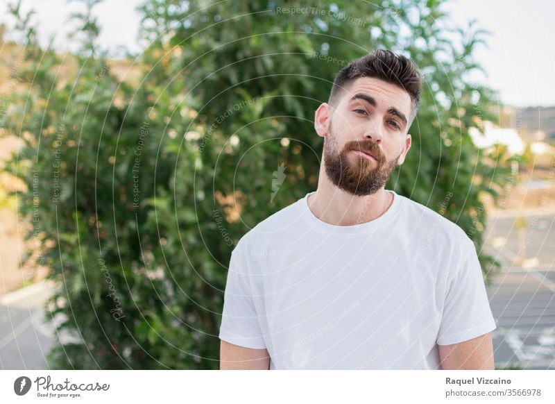 Hübscher Mann mit Bart und weißem T-Shirt im Freien. Porträt jung gutaussehend Glück Hemd Lächeln Person Menschen Park lässig Typ Gesicht Männer Vollbart