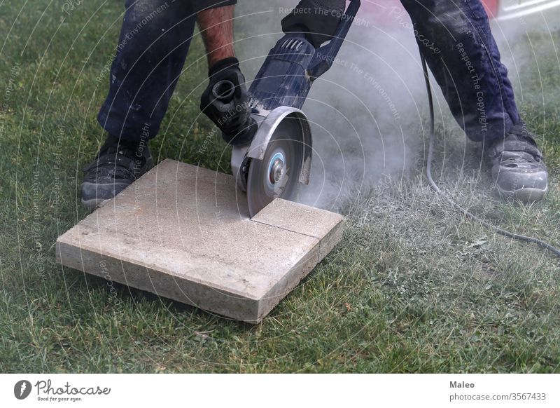 Industriebauarbeiter mit einem professionellen Winkelschleifer Baustein Schlacke kreisrund Nahaufnahme Kragen Beton Konstruktion kupfer Schnurlos Handwerk