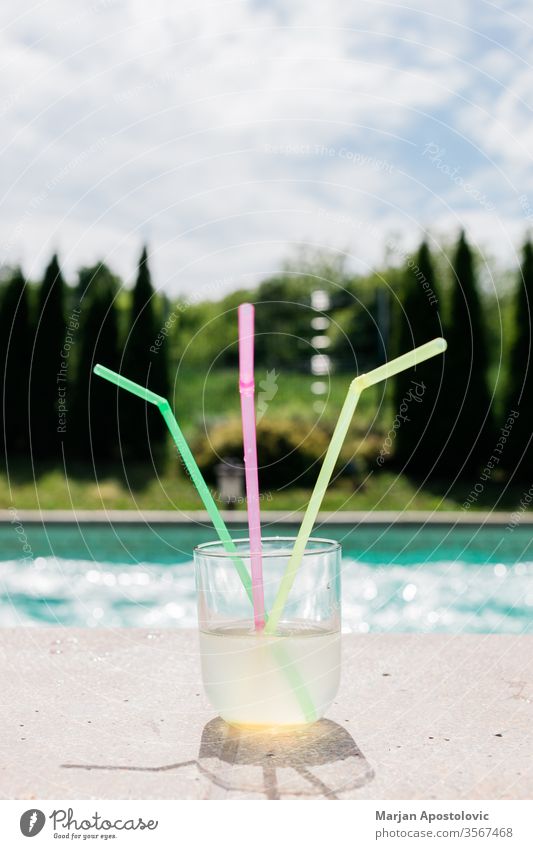 Glas Limonade mit drei Strohhalmen am Schwimmbad alkoholisch aqua Getränk blau Cocktail kalt farbenfroh Farben cool Kopie trinken genießen exotisch frisch