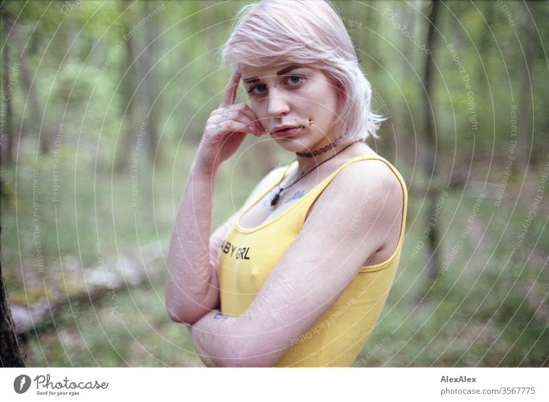 Analoges Portrait einer jungen Frau mit Piercings, Tätowierungen und Tunnel Mädchen blond Schmuck Assecoires Schulter Shirt Hemd schön draussen schauen