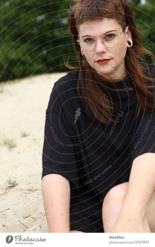 Portrait einer jungen Frau im Park Jugendliche schön stark alternativ groß Piercing Haut intensiv Blick schauen beaobachten stehen schlank ästhetisch sportlich