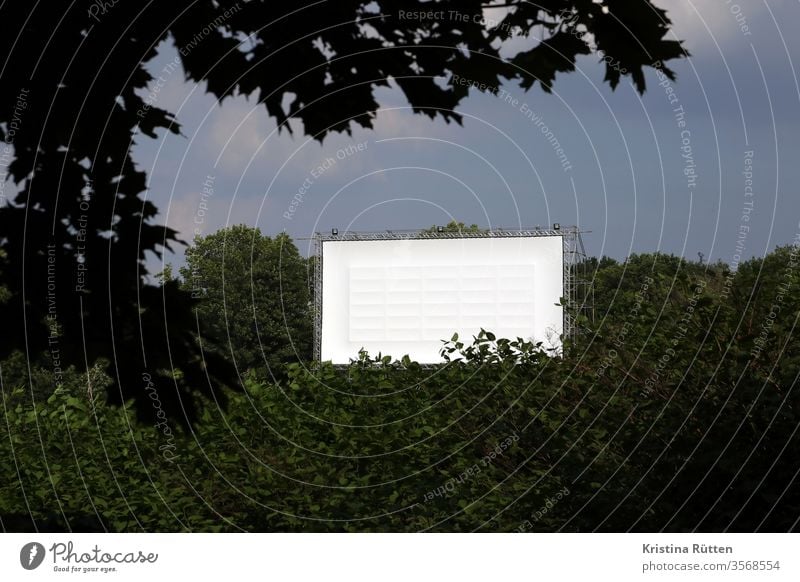 blick auf die weiße autokino leinwand open air kino popup-autokino freiluftkino bildwand kinoleinwand projektionsfläche draußen urban platz gerüst temporär