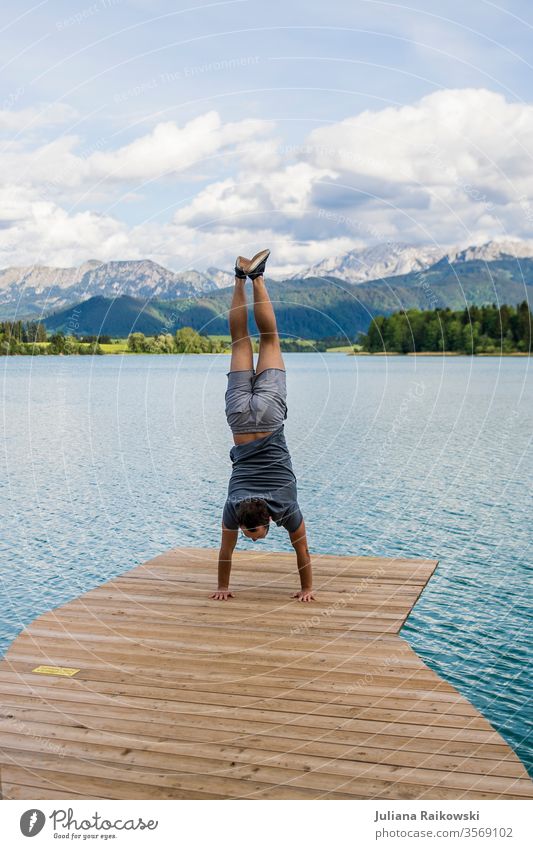 Mann macht Handstand vor einem wunderschönen Berg Panorama in Bayern Felsen Wetter malerisch wandern Ferien & Urlaub & Reisen Aussicht Außenaufnahme Farbfoto