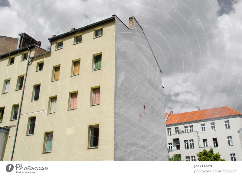 Ruhe vor dem Sturm im Kiez Neukölln Stadthaus Fassade Architektur Brandmauer Wolken Fenster Mietshaus Hinterhof authentisch Ecke Wolkenformation Wohngebiet