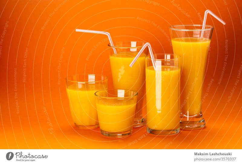 Gläser mit Orangensaft isoliert auf orangefarbenem Hintergrund Glas Saft Textfreiraum frisch Stroh Cocktail Gesundheit Lebensmittel Konzept abschließen